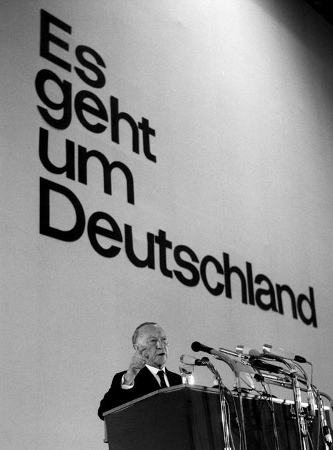 Adenauer vor einem Rednerpult und hinter ihm die Schrift "Es geht um Deutschland"