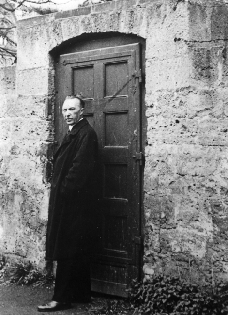 Schwarz-Weiss-Aufnahme von Konrad Adenauer vor einer Holztür