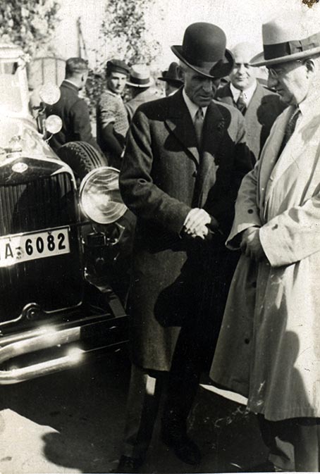 Schwarz-Weiss-Aufnahme von zwei Männern neben einem Automobil