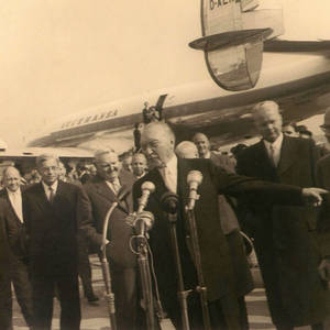 Aufnahme von Konrad Adenauer bei einer Pressekonferenz vor einem Flugzeug
