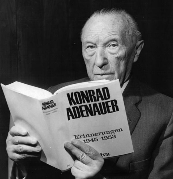 Konrad Adenauer sitzt mit seinem Buch in einem Sessel