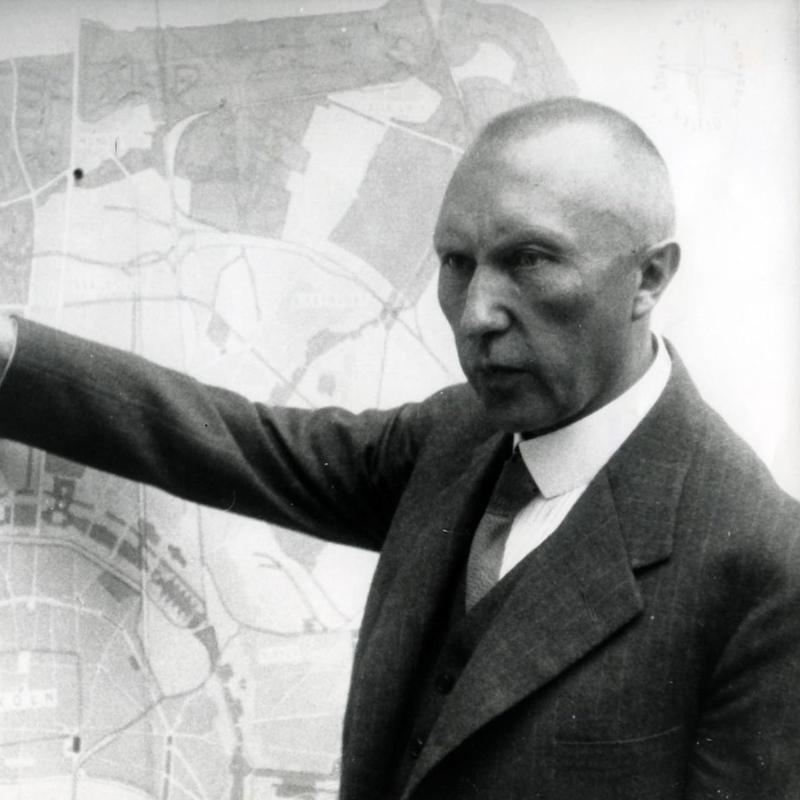 Oberbürgermeister Konrad Adenauer plant den Kölner Grüngürtel und zeigt auf einen Stadtplan Kölns