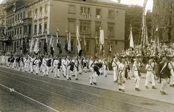 Schwarz-Weiss-Aufnahme von Herren mit Flaggen auf einem Umzug