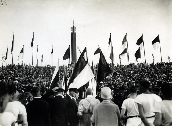 Schwarz-Weiss-Aufnahme von zahlreichen Zuschauern und aufgestellten Flaggen