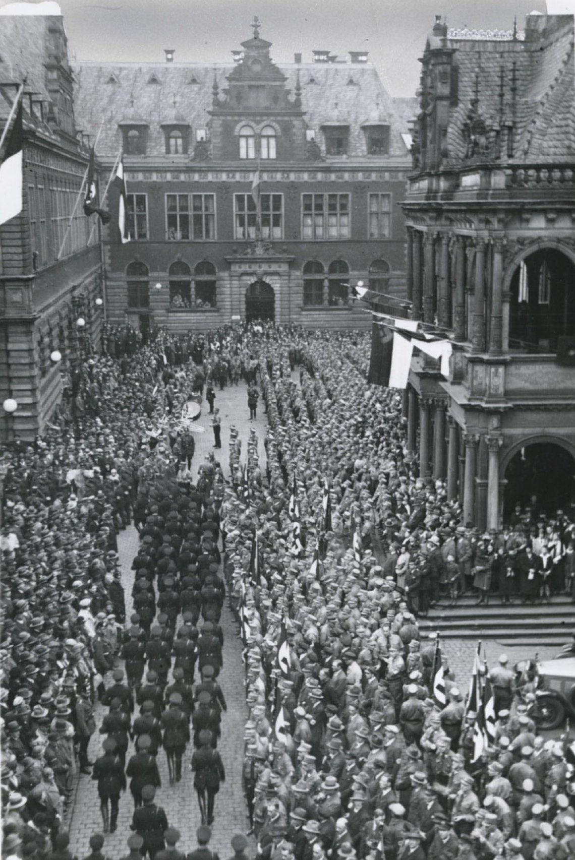 Nationalsozialisten marschieren vor dem Kölner Rathaus.