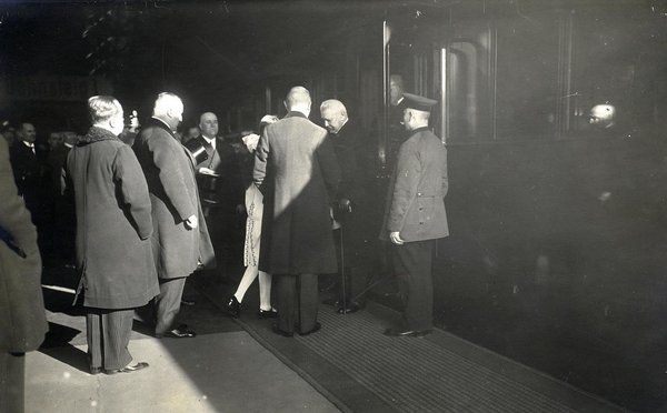 Schwarz-Weiss-Aufnahme von Paul von Hindenburg in einer Gruppe neben einem Zug