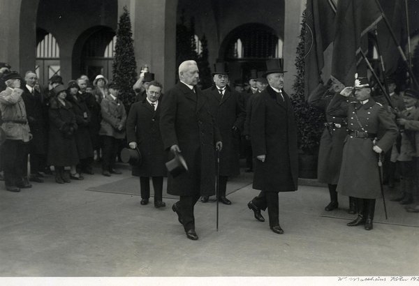Schwarz-Weiss-Aufnahme von Paul von Hindenburg und Konrad Adenauer beim Verlassen eines Gebäudes