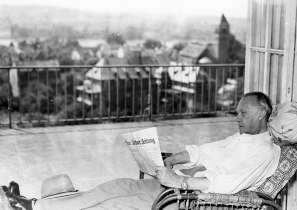 Schwarz-Weiss-Aufnahme von Konrad Adenauer im Liegestuhl beim Zeitunglesen