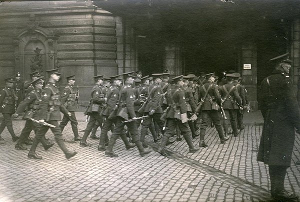Schwarz-Weiss-Aufnahme von Soldaten beim Betreten eines Gebäudes