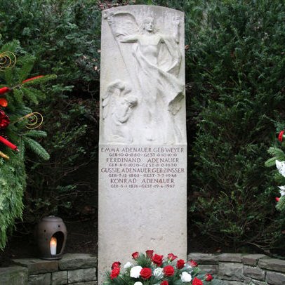 Grabstein Konrad Adenauers mit rot-weißen Bulmen davor