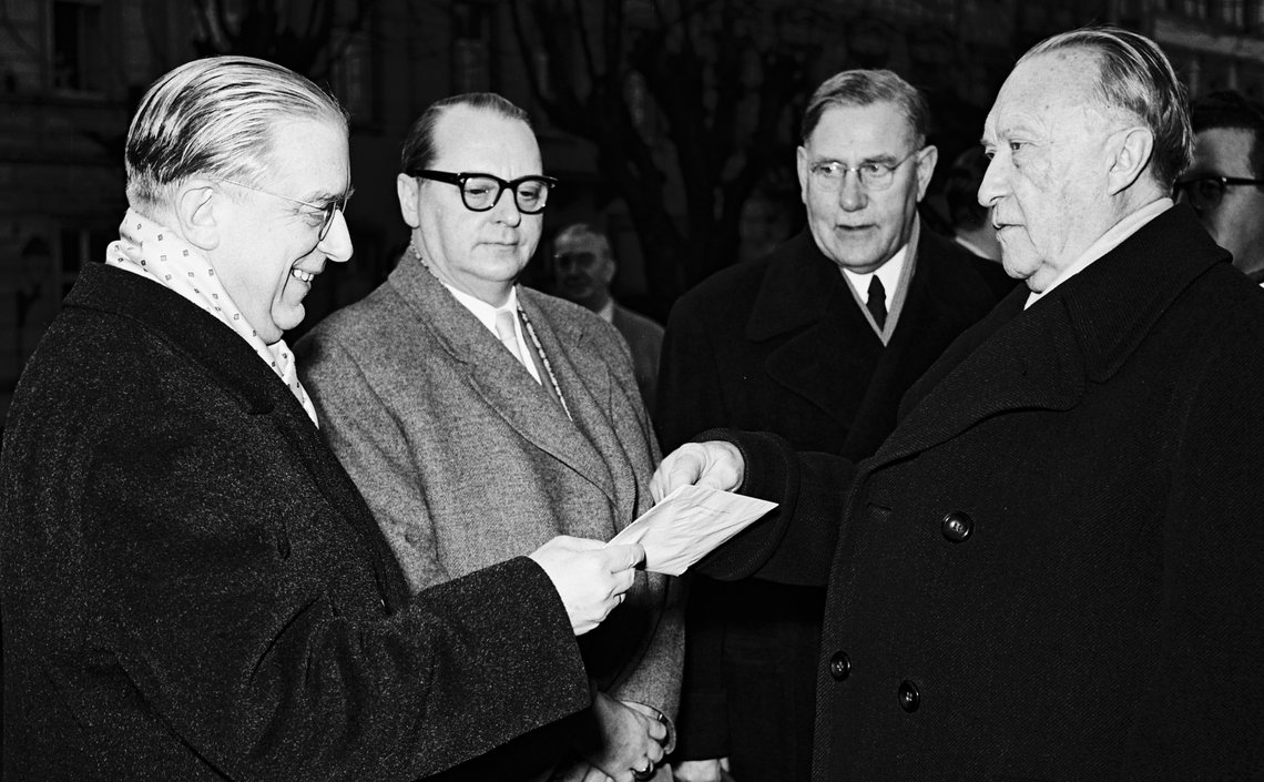 Adenauer, Hans Globke und Heinrich Krone sowie ein weiterer Mann stehen zusammen 