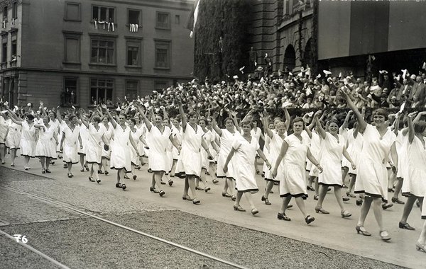Schwarz-Weiss-Aufnahme von Frauen in weißen Kleidern auf einem Umzug