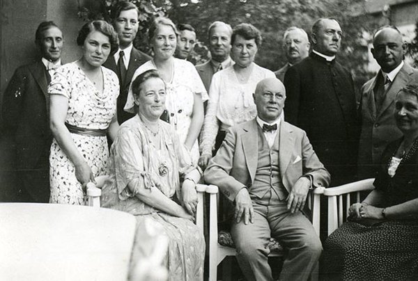 Schwarz-Weiss-Aufnahme von 13 Personen sitzend und stehend