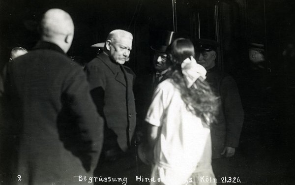 Schwarz-Weiss-Aufnahme von Paul von Hindenburg zu einem Mädchen gewandt