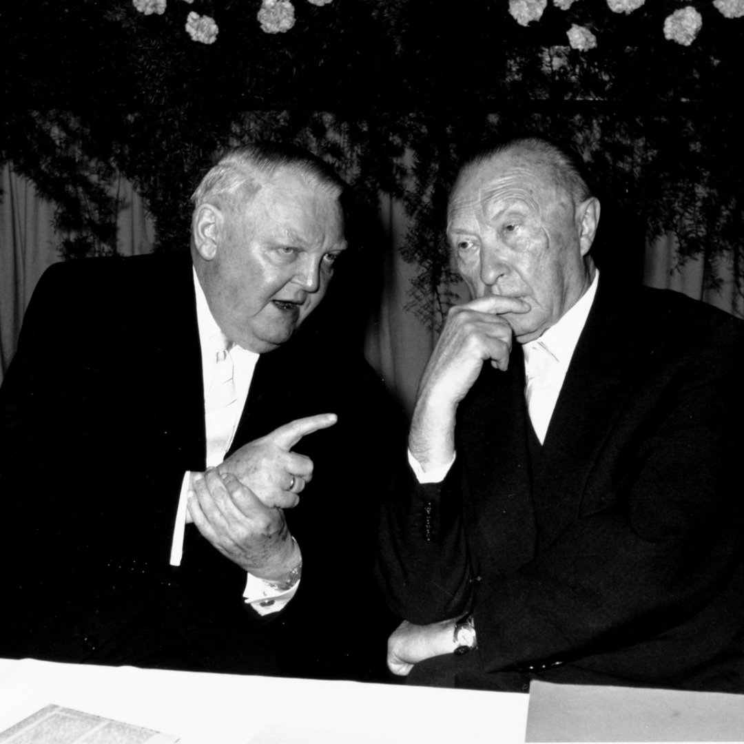 Ludwig Erhard und Konrad Adenauer sitzen und reden miteinander