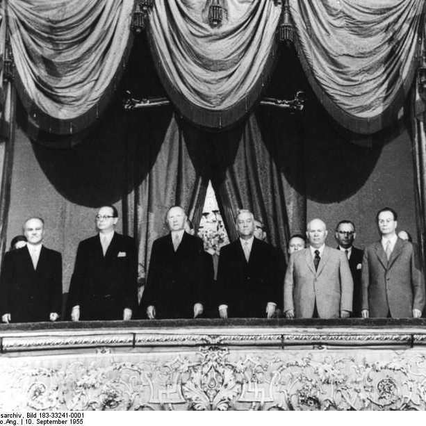 Adenauer und andere Männer stehn auf auf einer Empore im Theater