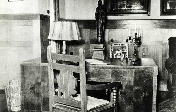 Schwarz-Weiss-Aufnahme von einem Schreitisch mit Holzstühlen