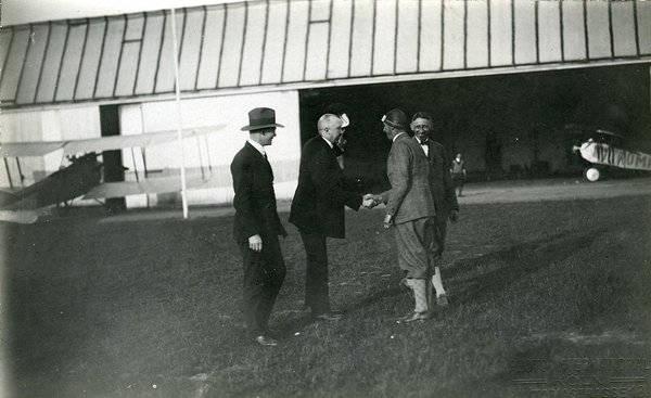 Schwarz-Weiss-Aufnahme von Konrad Adenauer mit seiner Familie und Pressevertretern auf dem Flugfeld