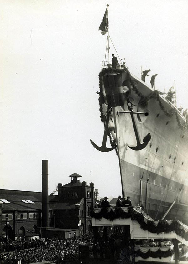 Schwarz-Weiss-Aufnahme von einem Schiff und zahlreichen Zuschauern im Hafen