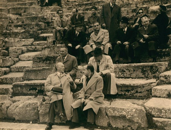 Schwarz-Weiss-Aufnahme von Konrad Adenauer mit 13 Personen auf einer großen Steintreppe