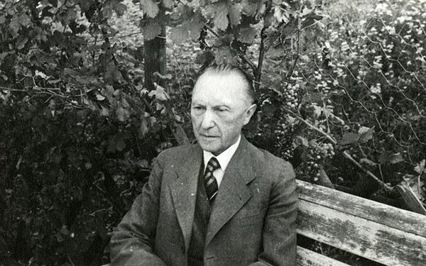 Schwarz-Weiss-Aufnahme von Konrad Adenauer auf einer Bank im Freien sitzend