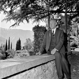 Schwarz-Weiss-Aufnahme von Konrad Adenauer auf einer Mauer sitzend