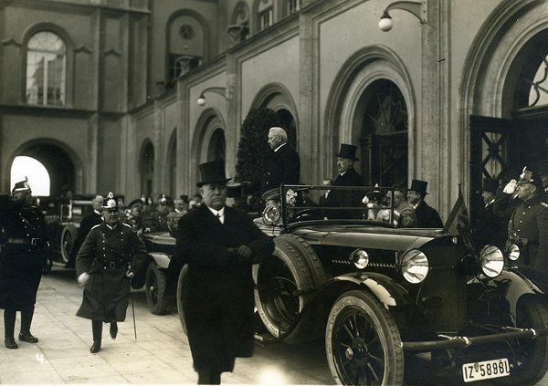 Schwarz-Weiss-Aufnahme von Paul von Hindenburg und Konrad Adenauer vor einem Automobil, umstehende Soldaten salutieren ihnen