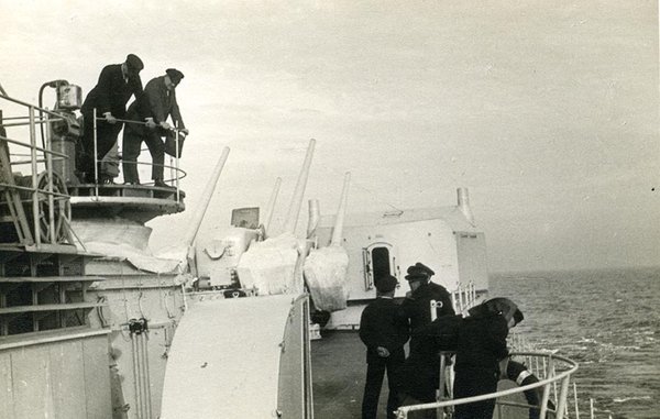 Schwarz-Weiss-Aufnahme von Herren auf einem Schiff auf hoher See