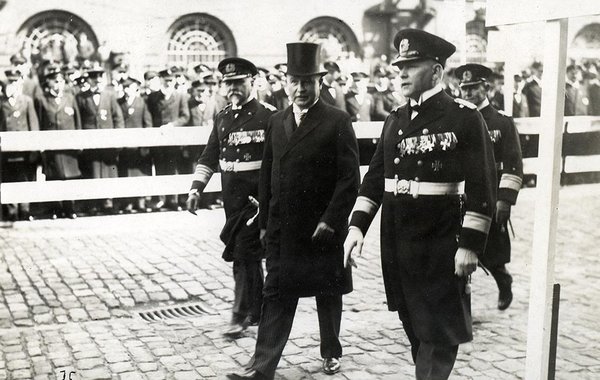 Schwarz-Weiss-Aufnahme von Konrad Adenauer im Zylinder mit drei Herren mit zahlreichen Orden
