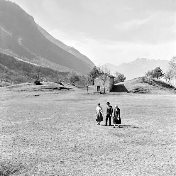 Schwarz-Weiss-Aufnahme von Konrad Adenauer mit Lotte Multhaupt und Libet Werhahn in freier Natur vor dem Alpenpanorama