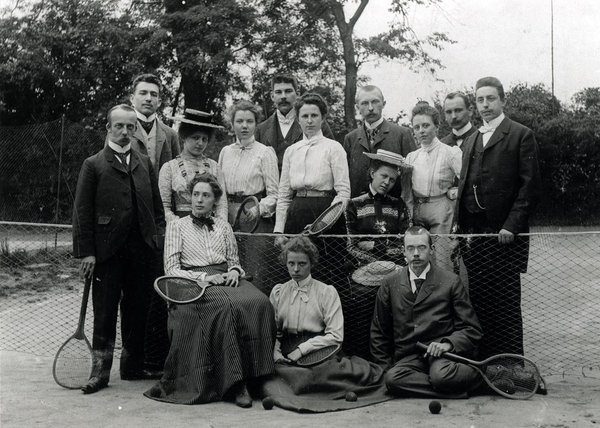 Schwarz-Weiss-Aufnahme von Konrad Adenauer mit 13 Personen auf dem Tennisplatz