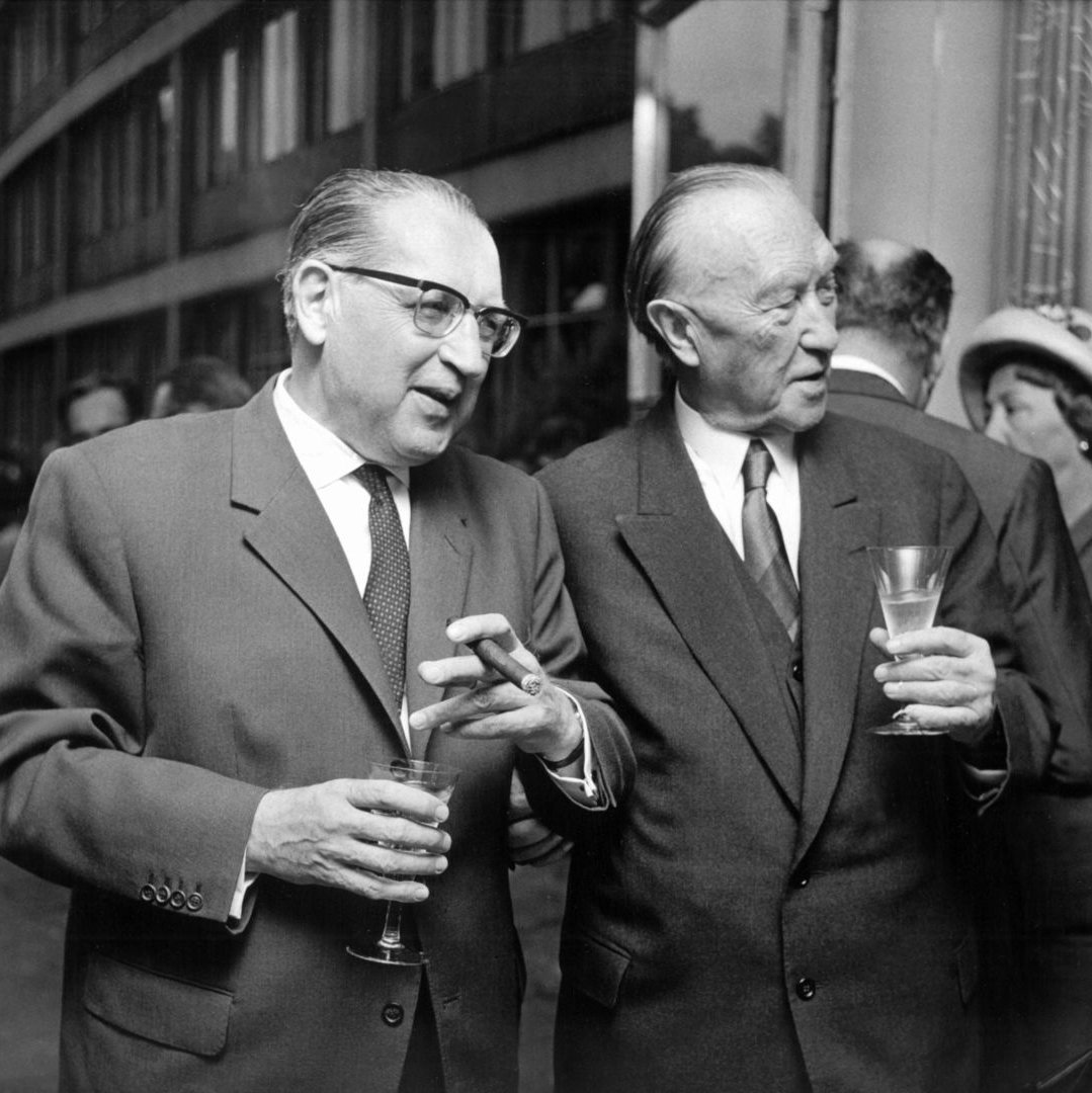 Der Vizepräsident de Deutschen Bundestages Thomas Dehler und Bundeskanzler Konrad Adenauer auf einer Party mit Gläsern in der Hand