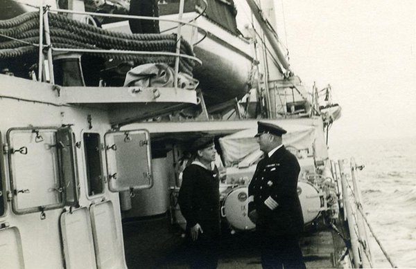 Schwarz-Weiss-Aufnahme von zwei Herren im Gespräch auf einem Schiff