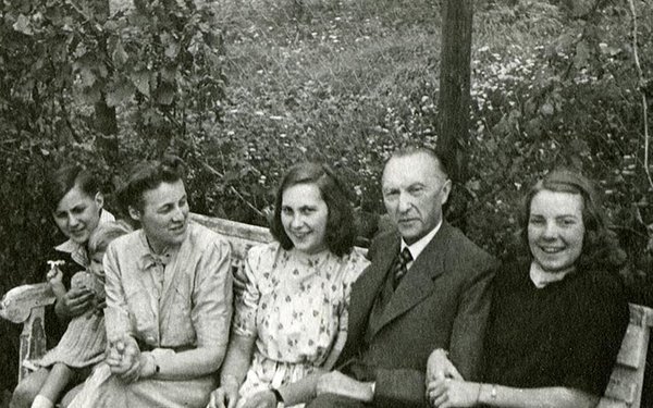 Schwarz-Weiss-Aufnahme von Familie Adenauer auf einer Bank im Freien
