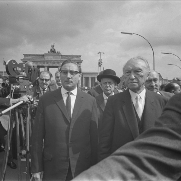 Adenauer und Amrehn stehen in einer Menschenmasse vor dem Brandenburger Tor.