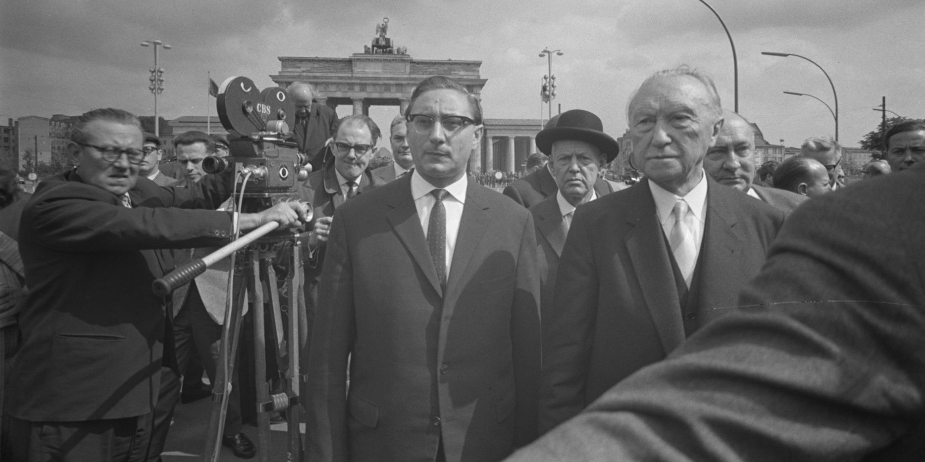 Adenauer und Amrehn stehen in einer Menschenmasse vor dem Brandenburger Tor.