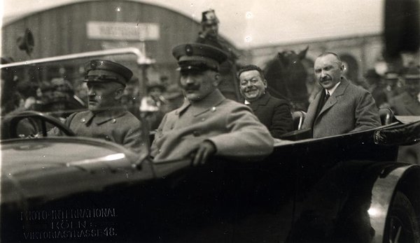 Schwarz-Weiss-Aufnahme von Konrad Adenauer mit drei Männern in einem Automobil